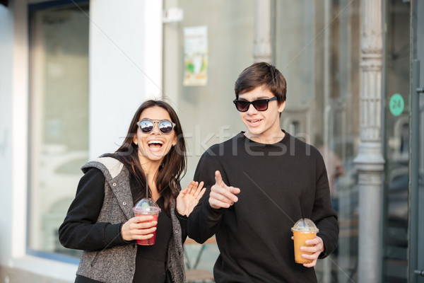 Happy young lady walking outdoors with her brother Stock photo © deandrobot