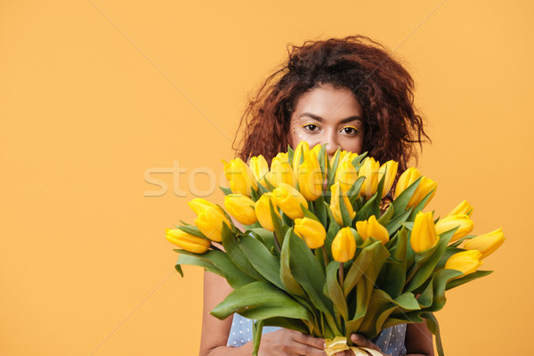 Close-up portrait of  African woman hiding behind bouquet  flowe Stock photo © deandrobot