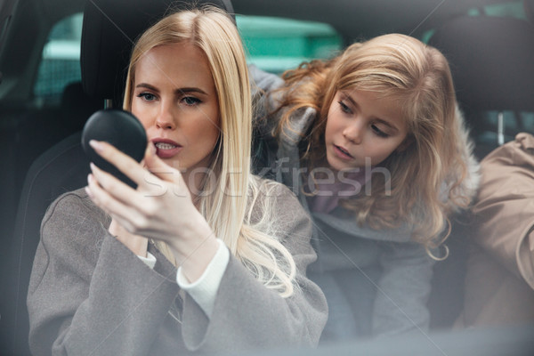 Woman doing makeup look at mirror Stock photo © deandrobot