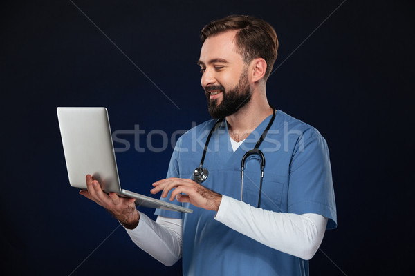 портрет мужской доктор равномерный стетоскоп используя ноутбук Сток-фото © deandrobot