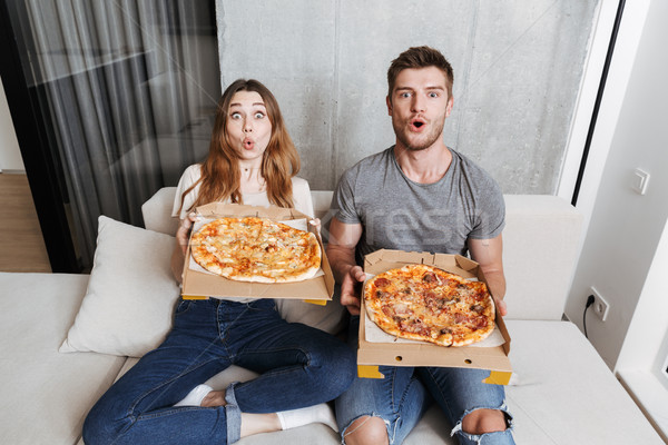 Excited young couple holding boxes with pizza Stock photo © deandrobot