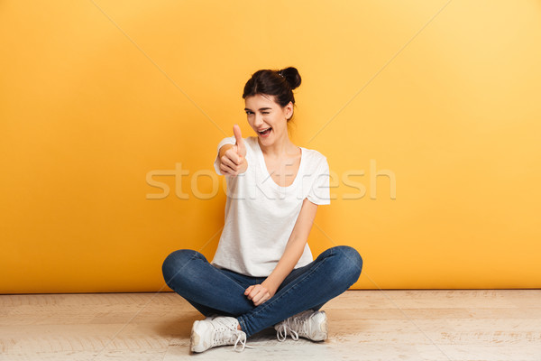 Retrato sorridente mulher jovem sessão as pernas cruzadas piso Foto stock © deandrobot
