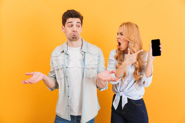 Photo of furious mad woman holding black smartphone and screamin Stock photo © deandrobot