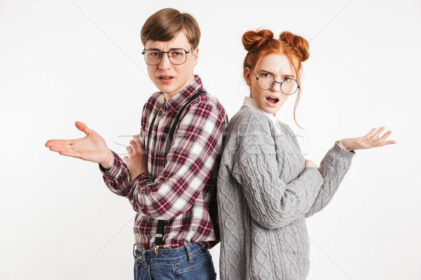 Confused couple of school nerds standing back to back Stock photo © deandrobot