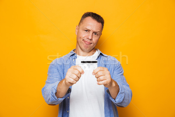 Portrait of an upset middle aged man showing credit card Stock photo © deandrobot