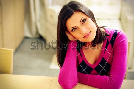 Young pensive woman sitting at the table at home Stock photo © deandrobot