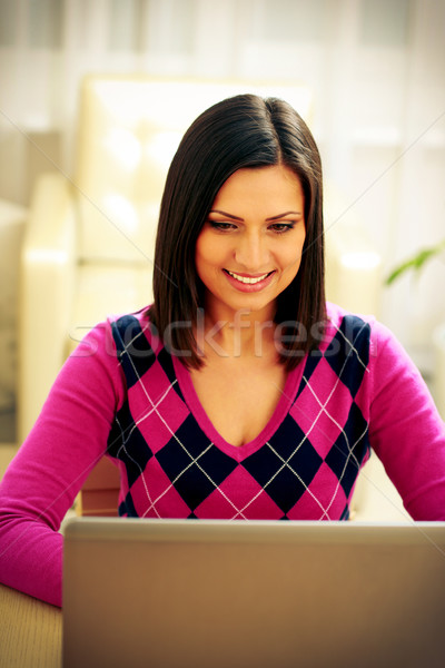 улыбающаяся женщина используя ноутбук домой женщину счастливым Сток-фото © deandrobot