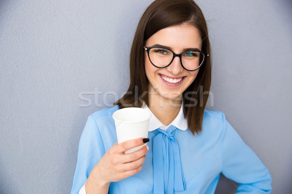 Smiling businesswoman holding cup with coffee  Stock photo © deandrobot