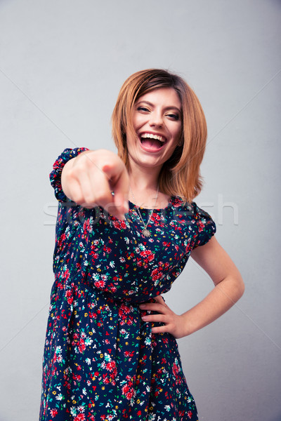 Kobieta wskazując kamery śmiechem szary dziewczyna Zdjęcia stock © deandrobot