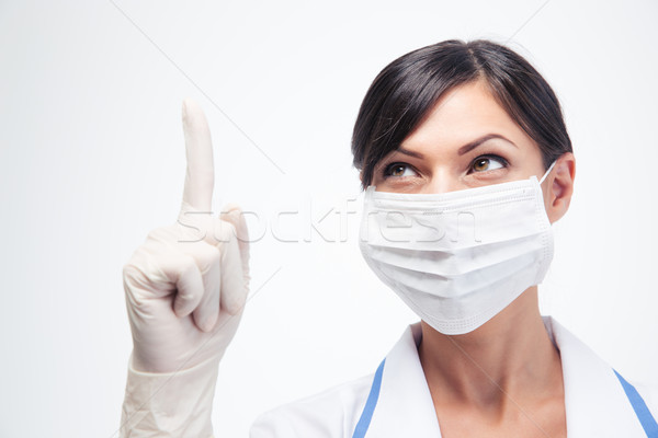 Medical doctor in mask pointing finger up Stock photo © deandrobot