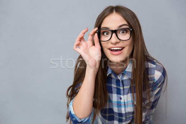 Ciekawy wesoły kobieta okulary patrząc kamery Zdjęcia stock © deandrobot