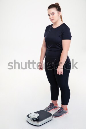 Fat woman standing with weighing machine Stock photo © deandrobot