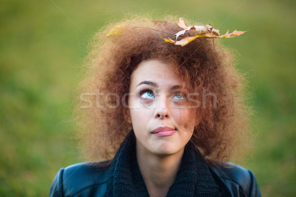 Woman looking up on leave in her curly hair Stock photo © deandrobot