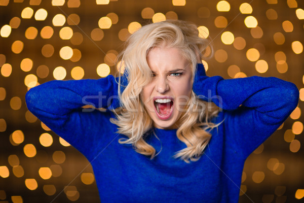 Blonde woman covering her ears and screaming Stock photo © deandrobot