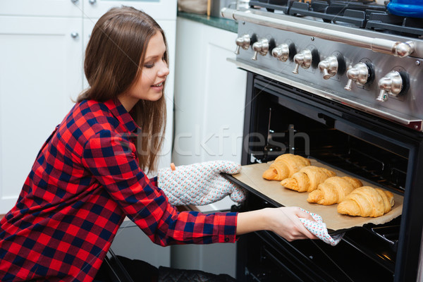 Mosolygó nő elvesz tálca croissantok sütő otthon Stock fotó © deandrobot