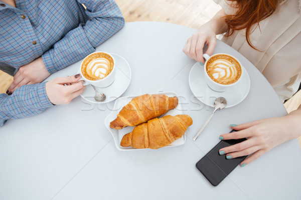 Topo ver duas mulheres potável café croissants Foto stock © deandrobot