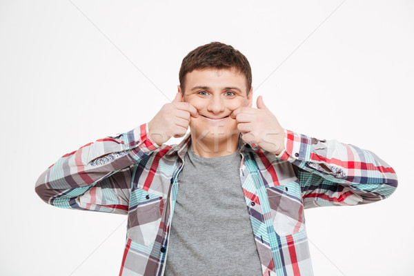 Young man making funny face Stock photo © deandrobot
