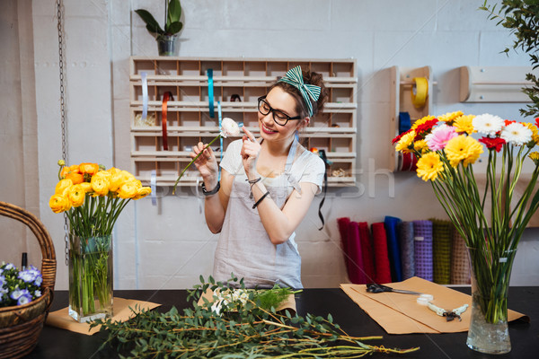 Happy woman florist enjoying white rose in flower shop Stock photo © deandrobot