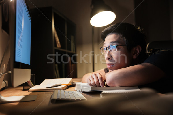 Tired bored man studying using books and computer at nighttime Stock photo © deandrobot