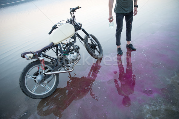 Image hommes permanent moto une bouteille d'eau Photo stock © deandrobot