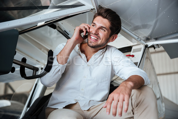 Man sitting in small plane and talking on mobile phone Stock photo © deandrobot