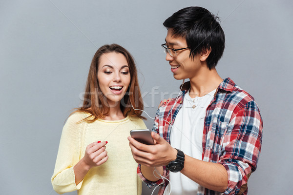 Couple listening to music with the same pair of earphones Stock photo © deandrobot