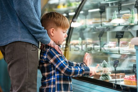 Dad and little son pointing at sweet cake in showcase Stock photo © deandrobot