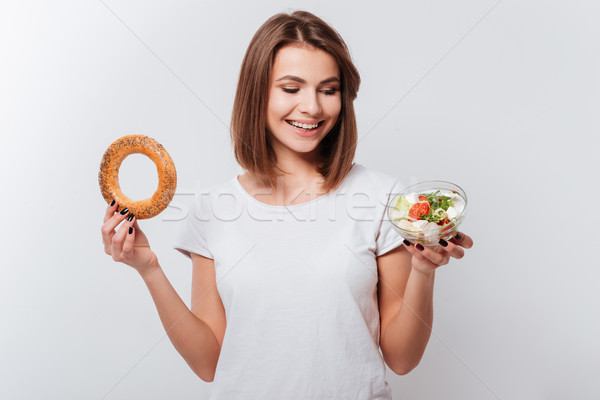 éhes fiatal nő tart bagel saláta kép Stock fotó © deandrobot