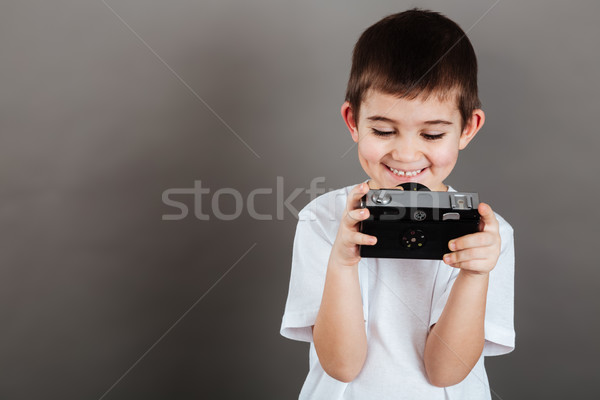 Stock photo: Cheerful little boy using and playing with photo camera