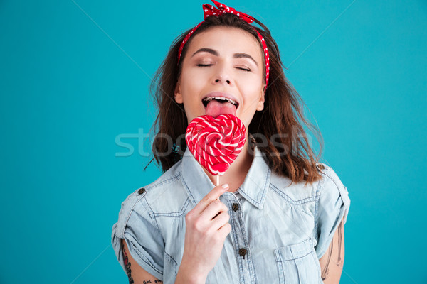 Stock photo: Happy woman standing isolated eating candy with eyes closed.