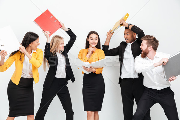 Happy woman holding folder while angry colleagues fighting Stock photo © deandrobot