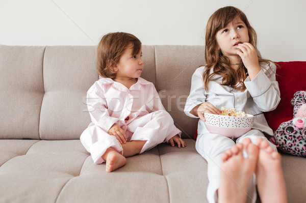 Foto stock: Irmã · olhando · mais · velho · alimentação · pipoca · sala · de · estar