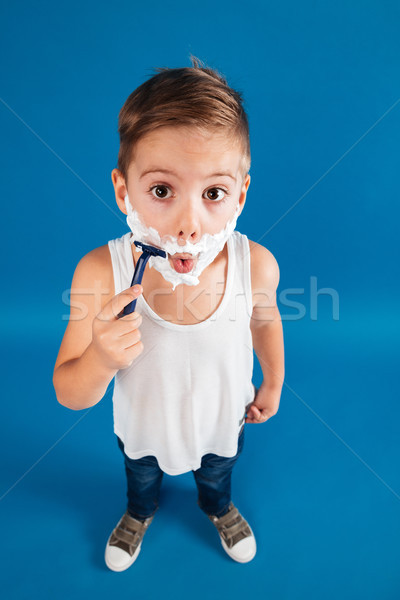 Vertical top view image of Young boy trying shaving face Stock photo © deandrobot