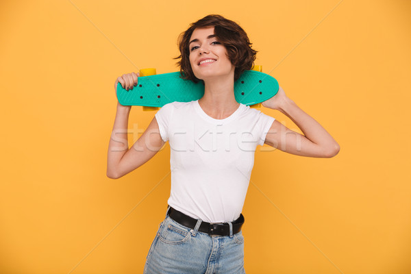 Stock photo: Portrait of a smiling young girl holding skateboard