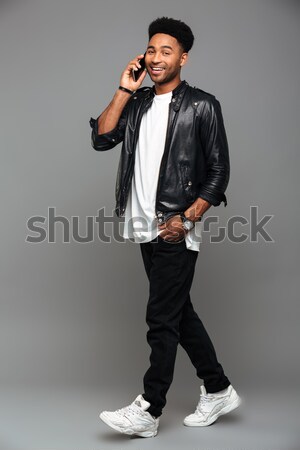 Full length photo of young cheerful african boy in leather jacke Stock photo © deandrobot
