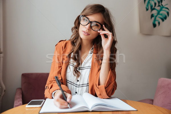 Portré gyönyörű nő jegyzetel jegyzettömb ül asztal Stock fotó © deandrobot
