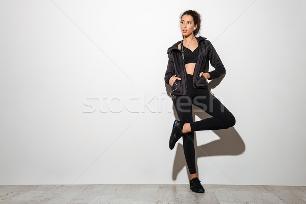 Full length image of Young curly brunette fitness woman Stock photo © deandrobot