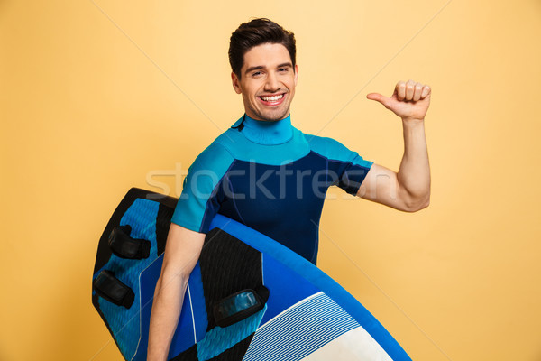 Portret uśmiechnięty młody człowiek strój kąpielowy wskazując palec Zdjęcia stock © deandrobot
