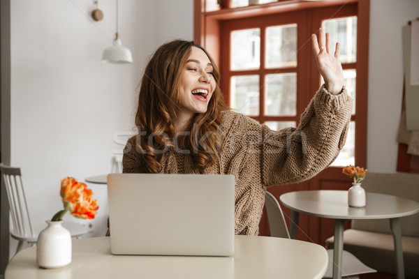 Photo of joyous young woman in sweater looking aside with broad  Stock photo © deandrobot