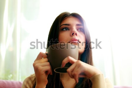 Young happy thoughtful woman using smartphone Stock photo © deandrobot