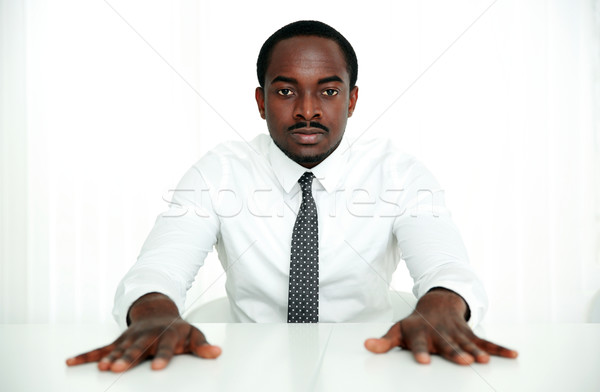 Komoly afrikai üzletember ül asztal iroda Stock fotó © deandrobot