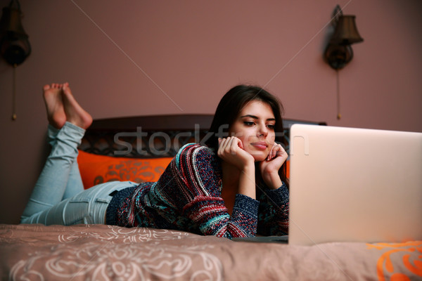 Mujer atractiva cama mirando portátil ordenador estudiante Foto stock © deandrobot