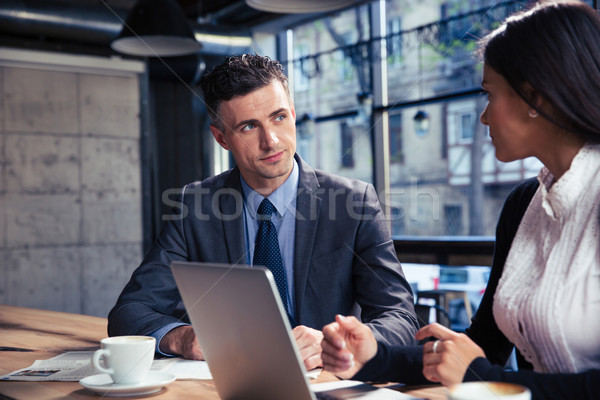 Stock photo: Businessman and businesswoman using laptop in cafe