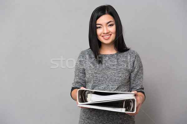 Asian girl holding documents in folders Stock photo © deandrobot
