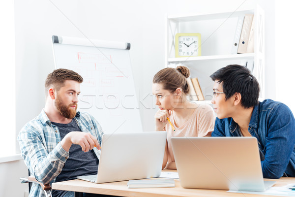 Three serious businesspeople having business meeting in office Stock photo © deandrobot