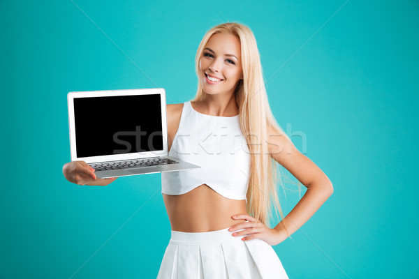 Portrait of a smiling cute woman showing laptop computer screen Stock photo © deandrobot
