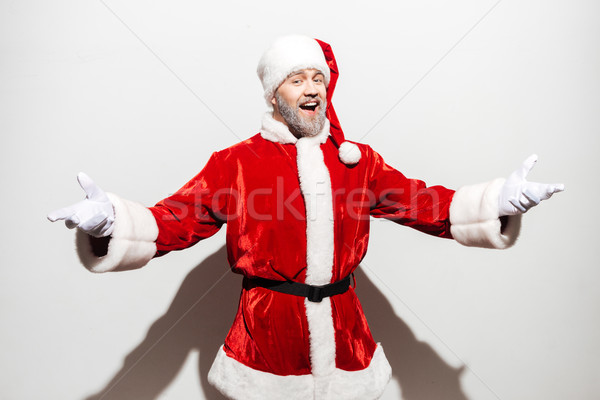 Happy man santa claus standing and showing welcome gesture Stock photo © deandrobot