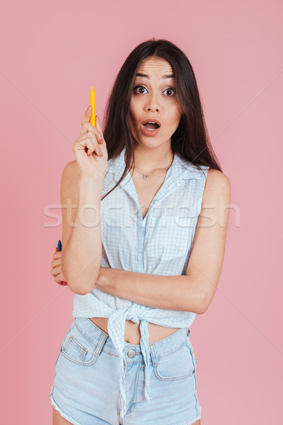 Shocked young lady holding wax crayons have an idea Stock photo © deandrobot