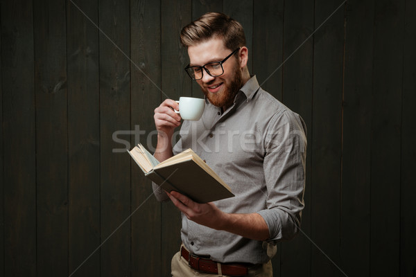 Homme lunettes lecture livre potable tasse [[stock_photo]] © deandrobot