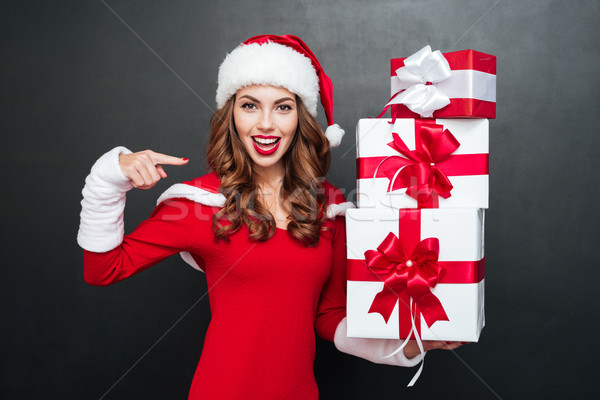 Woman in red dress pointing finger at stack of gifts Stock photo © deandrobot